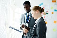 Man and woman looking at clipboard.